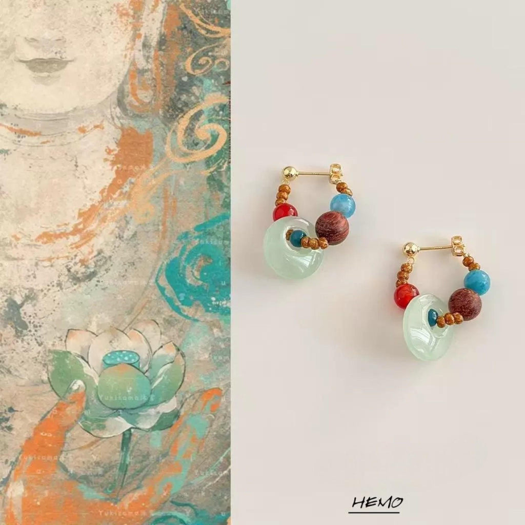 Handmade aquamarine and red agate earrings displayed on artistic background