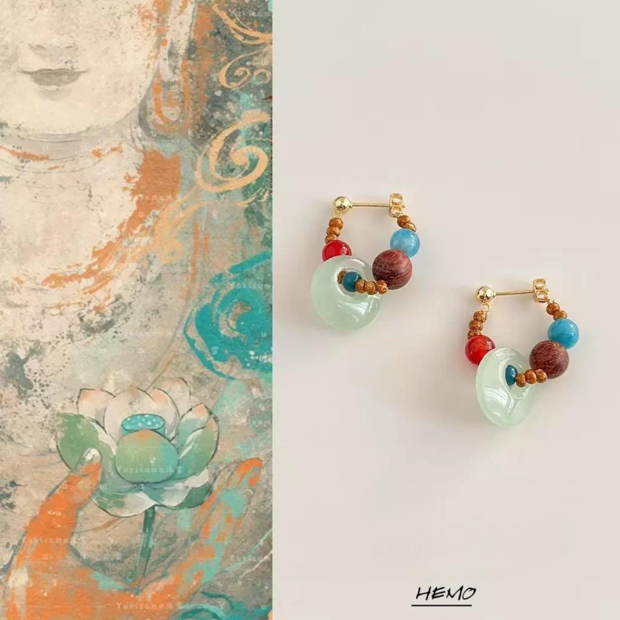Handmade aquamarine and red agate earrings displayed on artistic background